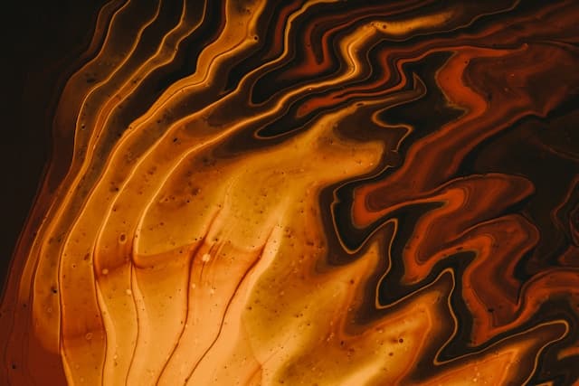 Abstract artwork with warm, flowing colors of orange, red, and gold